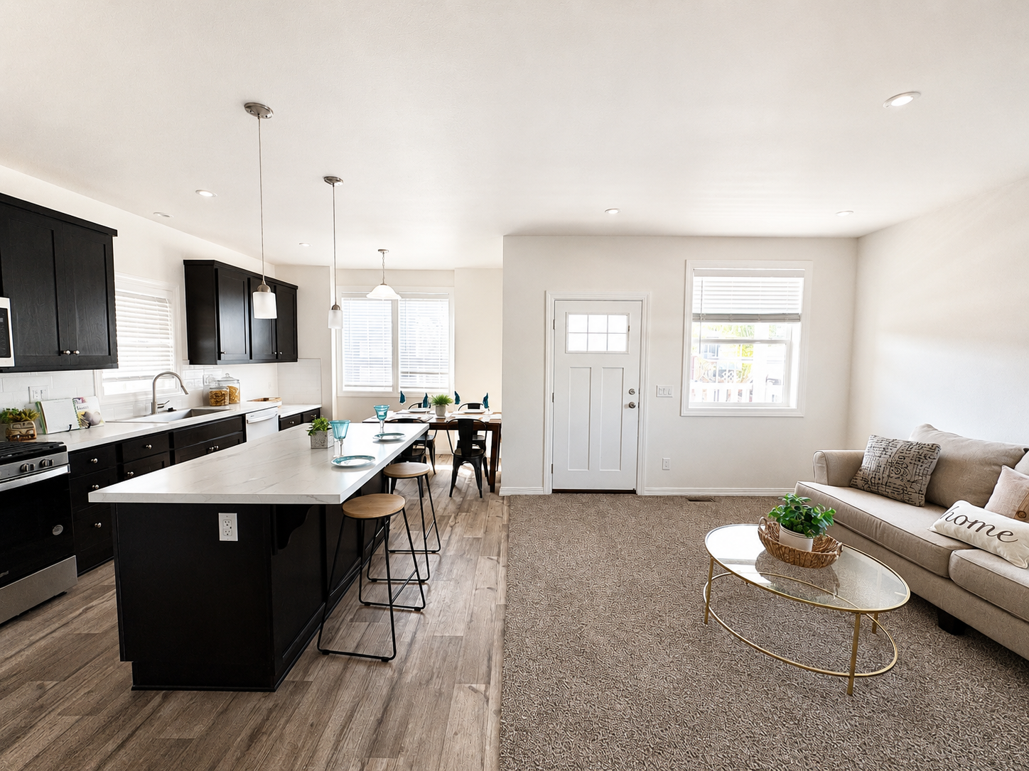 Pacific Vegas 7 living area with kitchen island and seating, couch and front door with a big window